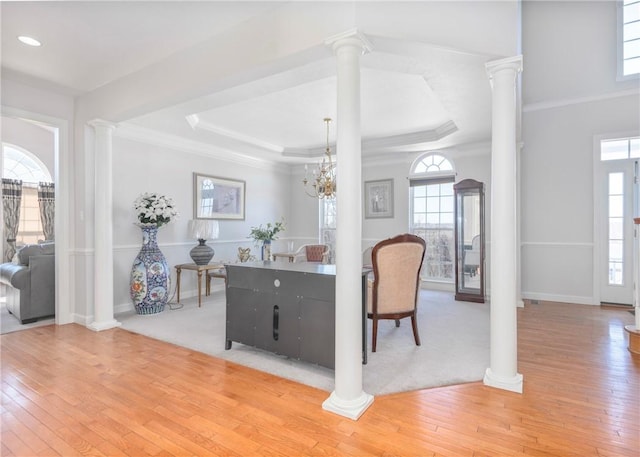 foyer entrance featuring hardwood / wood-style flooring, a healthy amount of sunlight, and ornate columns