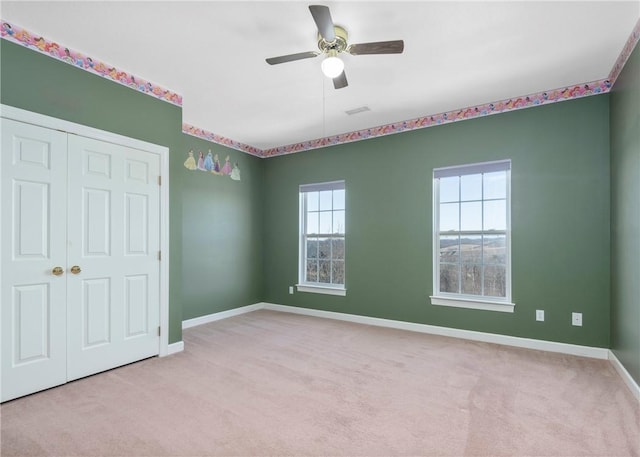 unfurnished bedroom featuring carpet flooring, visible vents, baseboards, and a closet