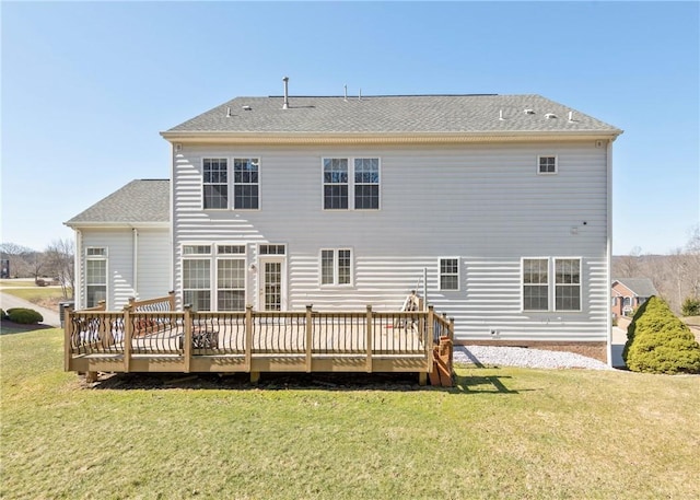 rear view of house featuring a yard, roof with shingles, and a wooden deck