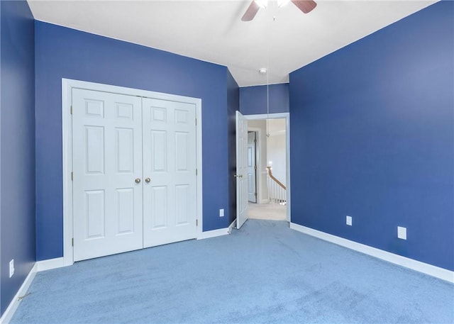 unfurnished bedroom featuring carpet flooring, baseboards, a closet, and ceiling fan