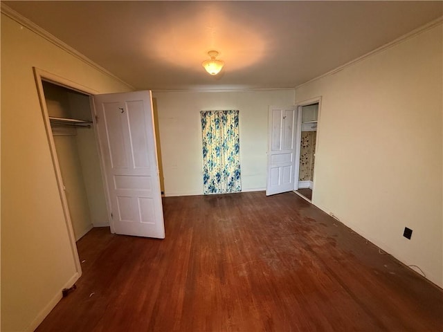 unfurnished bedroom featuring a closet, wood finished floors, and crown molding