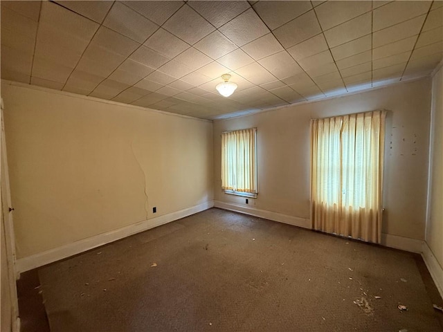 empty room featuring a wealth of natural light and baseboards