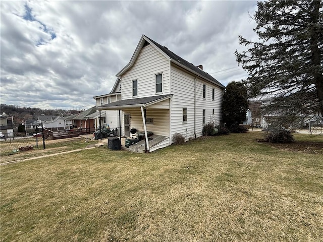 view of property exterior featuring a lawn and fence