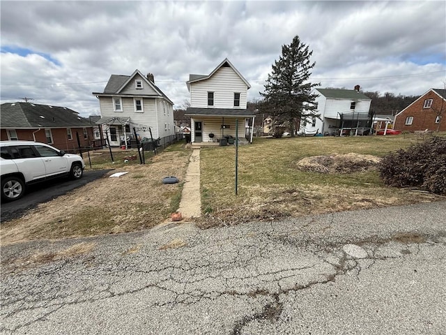 view of front of home with a front lawn and fence