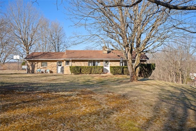 ranch-style home featuring a chimney and a front lawn