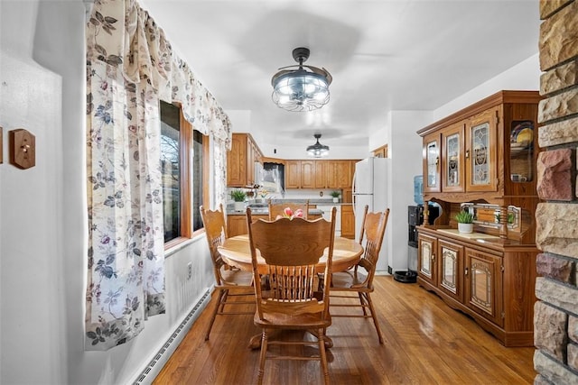 dining space with light wood-type flooring and a baseboard radiator