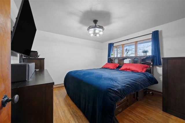 bedroom featuring baseboards and wood finished floors