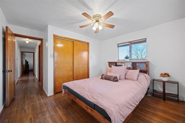 bedroom with hardwood / wood-style floors, a ceiling fan, a closet, and baseboards