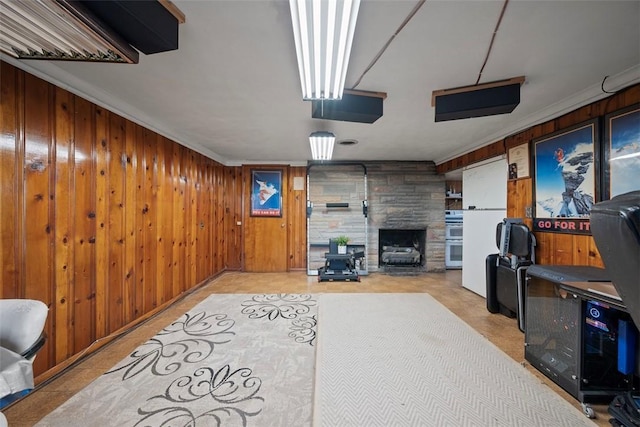 living room featuring wooden walls, a fireplace, and ornamental molding