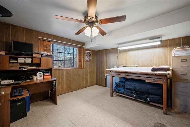 office featuring light floors, wood walls, and a ceiling fan