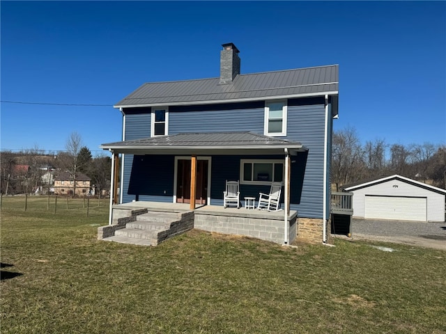 view of front of house with a front lawn, covered porch, a chimney, metal roof, and an outbuilding