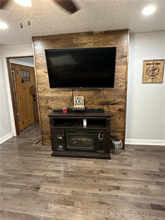 details with a textured ceiling, baseboards, and wood finished floors