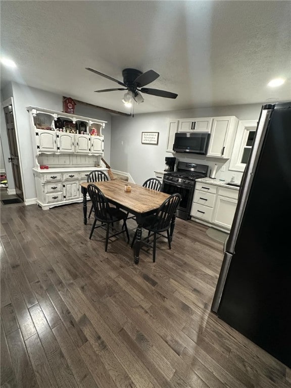 dining room with baseboards, a textured ceiling, dark wood finished floors, and a ceiling fan