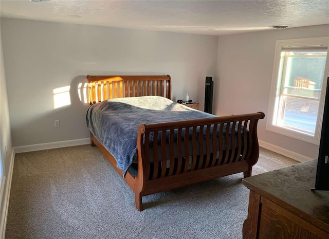 bedroom featuring baseboards, carpet, and a textured ceiling