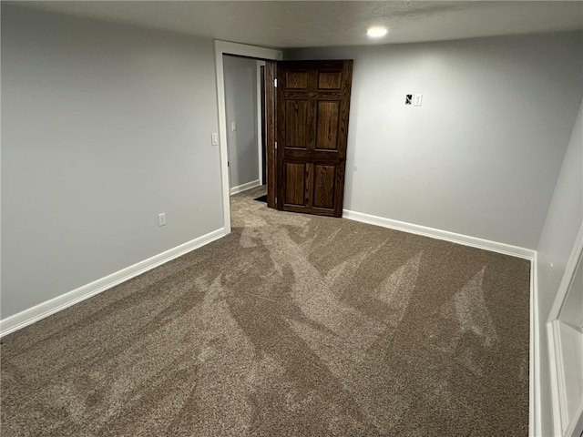 unfurnished room with baseboards and carpet flooring