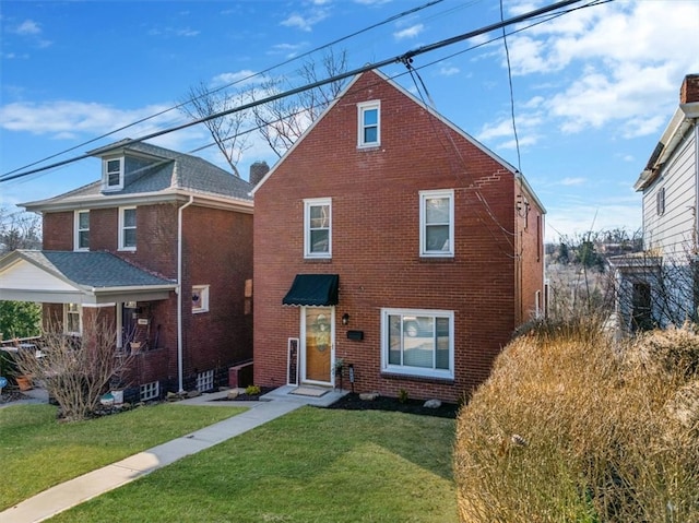 view of front facade with brick siding and a front yard