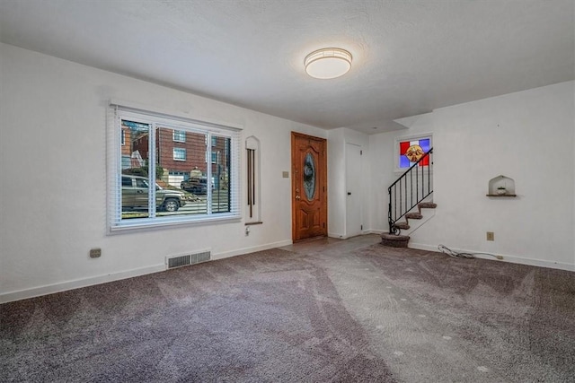 entryway featuring visible vents, stairway, baseboards, and carpet