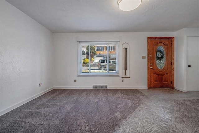 carpeted spare room featuring visible vents and baseboards