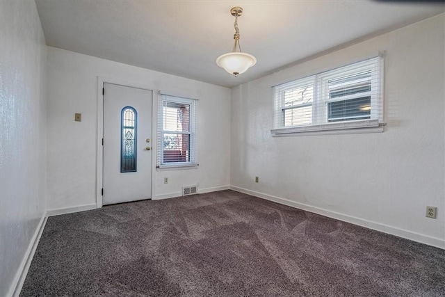 unfurnished room with carpet flooring, a healthy amount of sunlight, visible vents, and baseboards