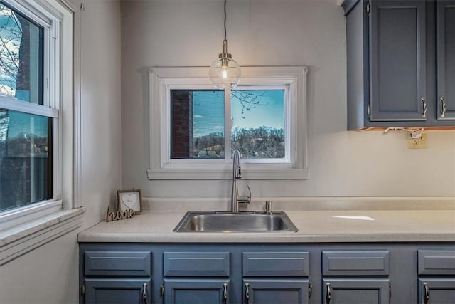 kitchen with a sink, gray cabinetry, and light countertops