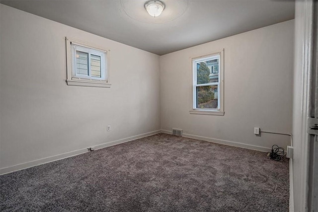 unfurnished room with visible vents, baseboards, and carpet