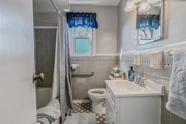 full bathroom featuring toilet, vanity, tile walls, and shower / bathtub combination with curtain