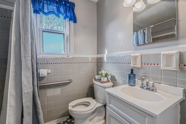 full bathroom with toilet, vanity, wainscoting, a shower with curtain, and tile walls