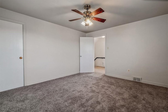 unfurnished room featuring a ceiling fan, carpet, visible vents, and baseboards