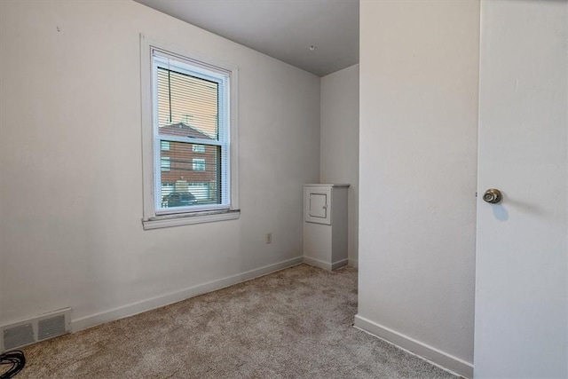 carpeted spare room with visible vents and baseboards