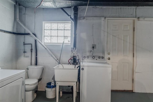 laundry area with washer / clothes dryer, concrete block wall, and a sink