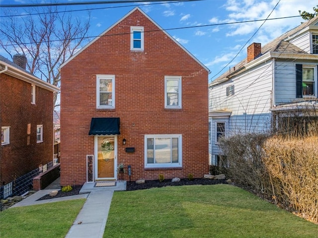 view of front of property featuring a front yard and brick siding