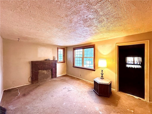 unfurnished living room featuring baseboards, a textured ceiling, a brick fireplace, and carpet floors