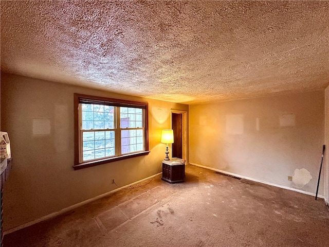 carpeted empty room with visible vents, a textured ceiling, and baseboards