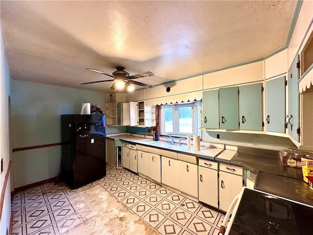 kitchen with a ceiling fan, a sink, open shelves, freestanding refrigerator, and range