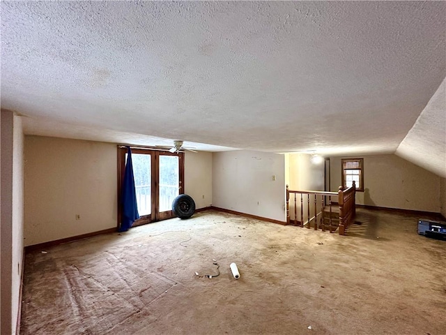 unfurnished room with plenty of natural light, a textured ceiling, and baseboards