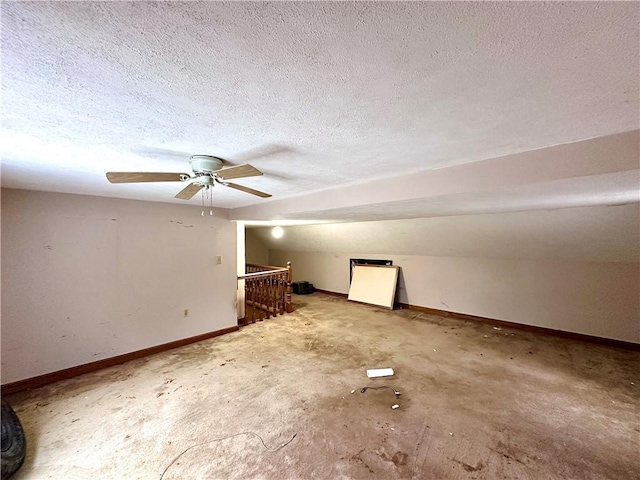 additional living space featuring vaulted ceiling, baseboards, and a textured ceiling