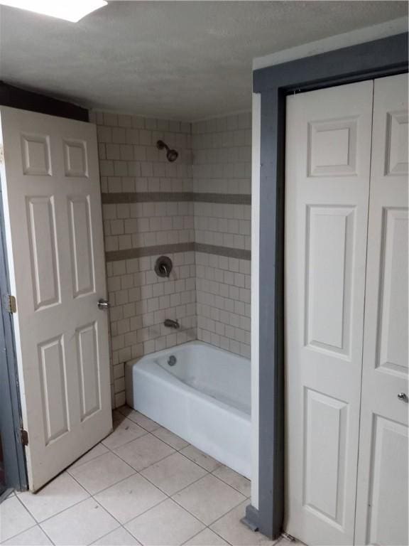 full bath with tile patterned floors and washtub / shower combination