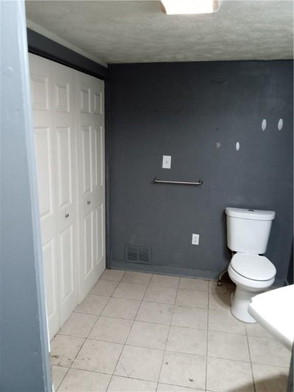 bathroom featuring tile patterned flooring, toilet, and visible vents