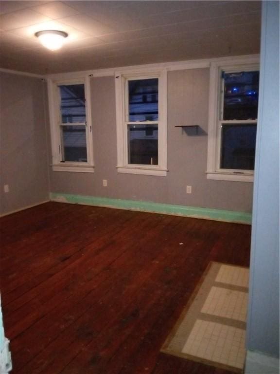 empty room featuring wood finished floors and baseboards