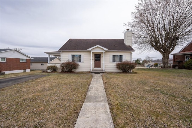 view of front of property with a chimney and a front lawn