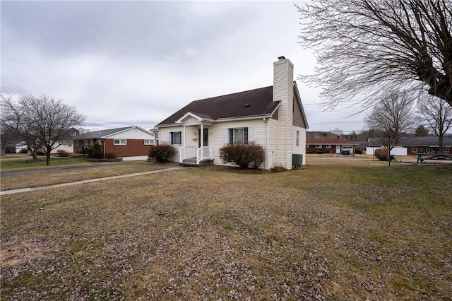 view of front of house with a chimney and a front lawn