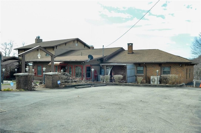 view of front of property featuring brick siding and a chimney