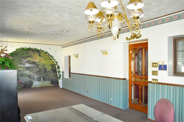 empty room with an inviting chandelier, carpet, and a wainscoted wall
