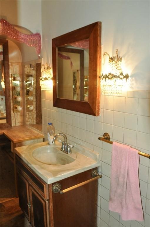 bathroom with a wainscoted wall, vanity, and tile walls