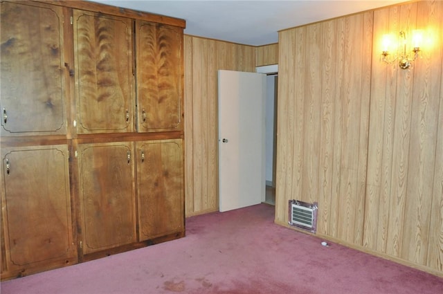 unfurnished bedroom featuring carpet flooring and wood walls