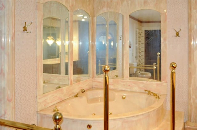 full bath with toilet, a jetted tub, and wallpapered walls