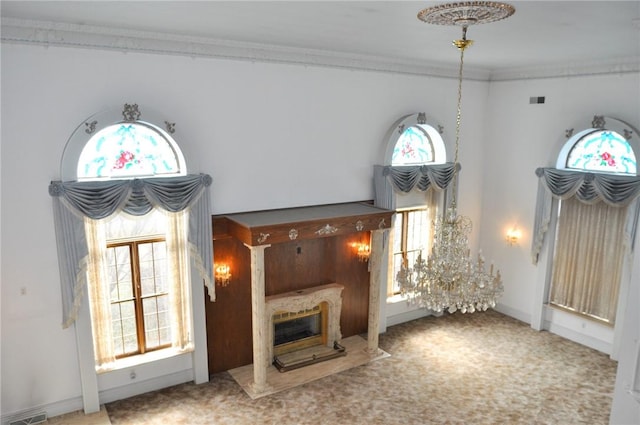 unfurnished living room with baseboards, visible vents, carpet floors, a fireplace, and ornamental molding