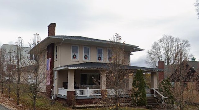 view of front of home with a porch and a chimney