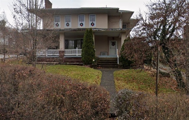 view of front facade with a porch and stucco siding