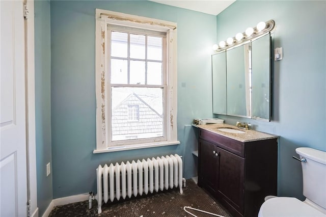 bathroom featuring vanity, toilet, radiator heating unit, and baseboards